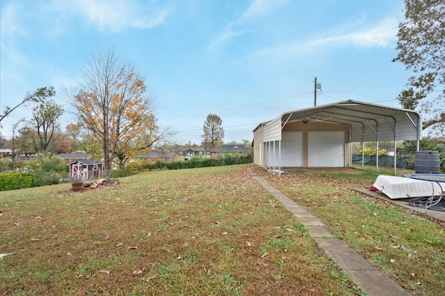 view of yard featuring central AC unit, a garage, a carport, and a storage unit