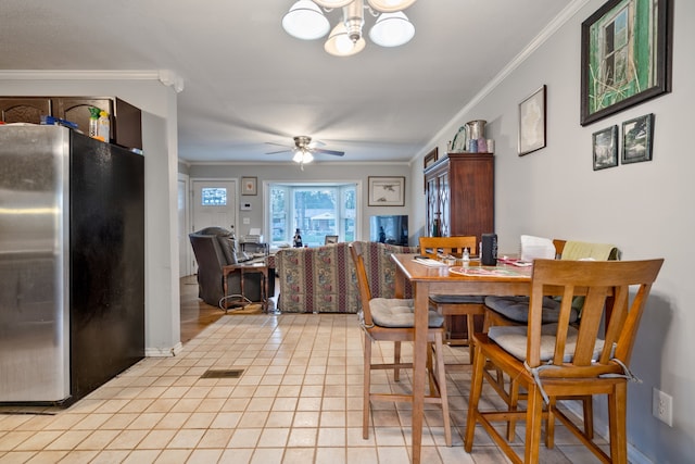 dining area featuring ceiling fan with notable chandelier, light tile patterned flooring, and crown molding