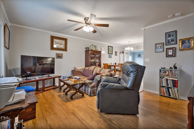 living room featuring hardwood / wood-style floors, ornamental molding, and ceiling fan with notable chandelier