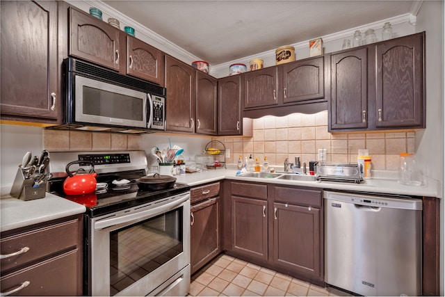 kitchen featuring dark brown cabinetry, appliances with stainless steel finishes, sink, and crown molding