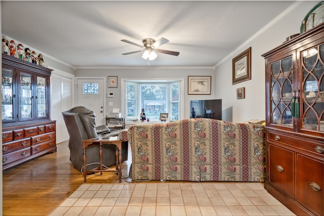 living room featuring ornamental molding, light hardwood / wood-style flooring, and ceiling fan