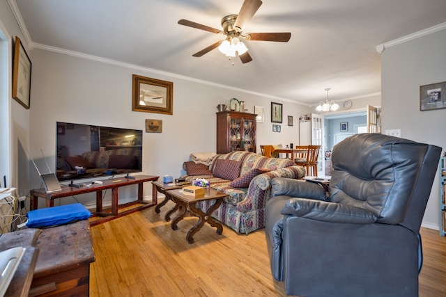 living room featuring hardwood / wood-style floors, ornamental molding, and ceiling fan with notable chandelier