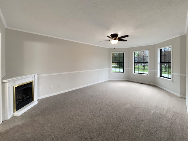 unfurnished living room with ceiling fan, ornamental molding, a textured ceiling, and carpet