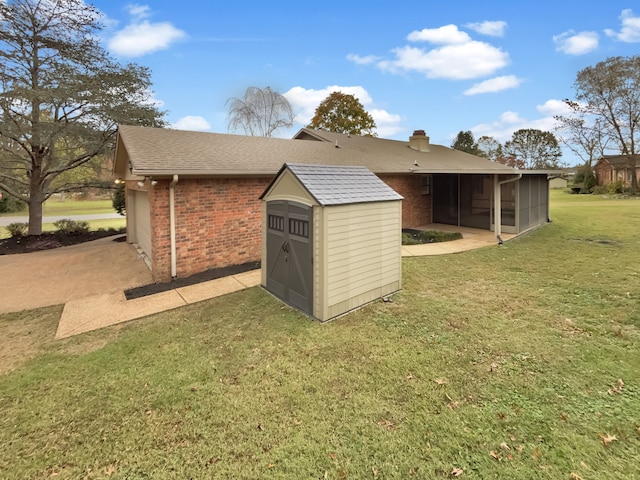 view of outbuilding featuring a sunroom and a yard