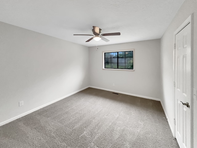 unfurnished room with dark colored carpet and ceiling fan