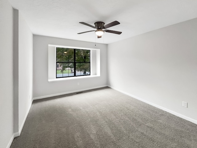 carpeted spare room featuring ceiling fan