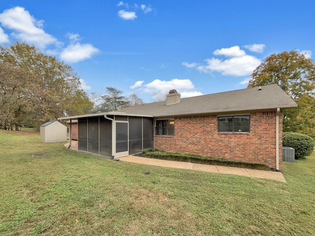 back of house featuring cooling unit, a sunroom, and a yard