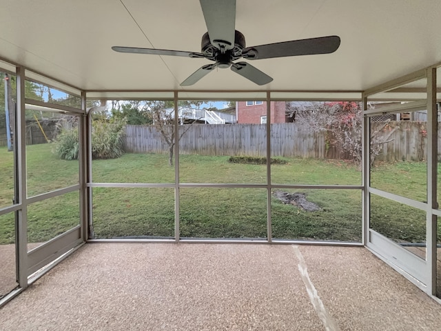 unfurnished sunroom with ceiling fan