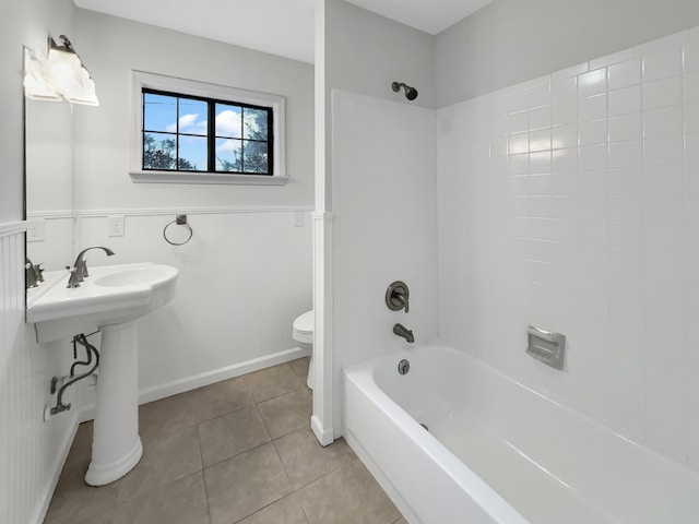 full bathroom featuring washtub / shower combination, tile patterned floors, toilet, and sink