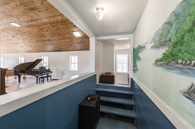 stairs with vaulted ceiling, wooden ceiling, and a healthy amount of sunlight