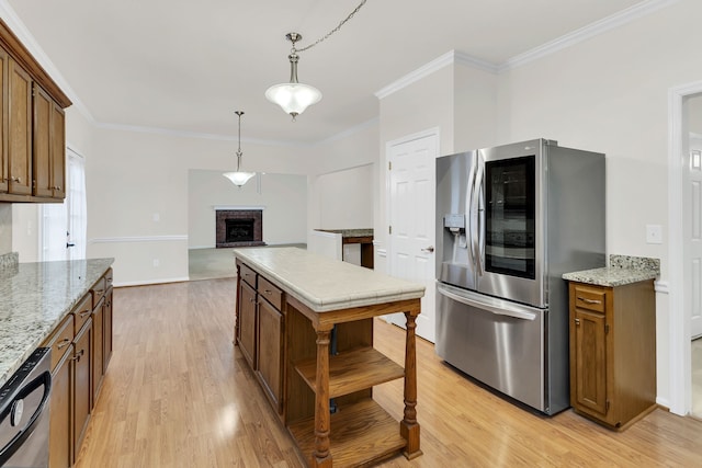 kitchen with light hardwood / wood-style floors, ornamental molding, and stainless steel appliances