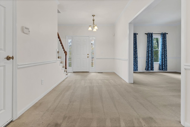 carpeted foyer entrance featuring an inviting chandelier and ornamental molding