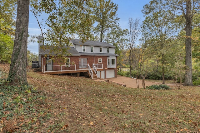 back of property with central AC unit, a garage, and a deck