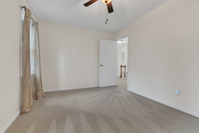 spare room featuring light carpet and ceiling fan