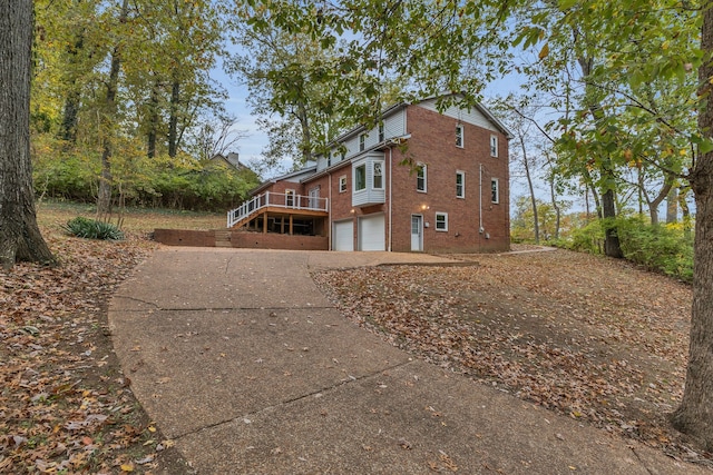 view of side of home with a wooden deck and a garage