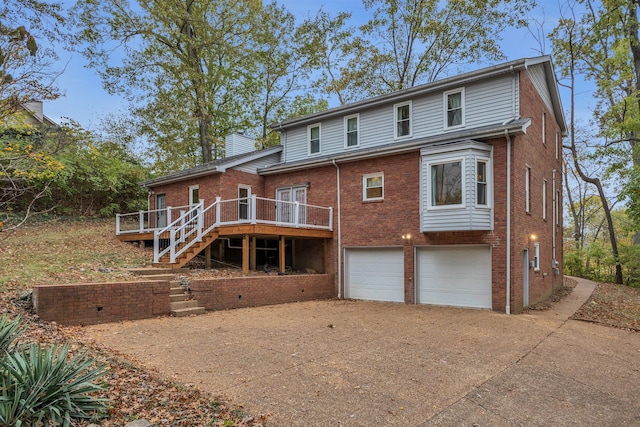 rear view of house featuring a wooden deck and a garage