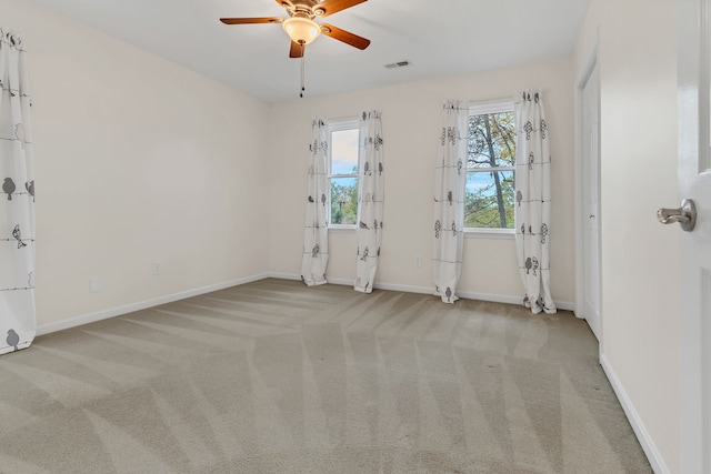 empty room featuring ceiling fan and light carpet