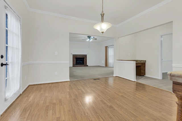 unfurnished living room featuring crown molding, ceiling fan, plenty of natural light, and light hardwood / wood-style floors