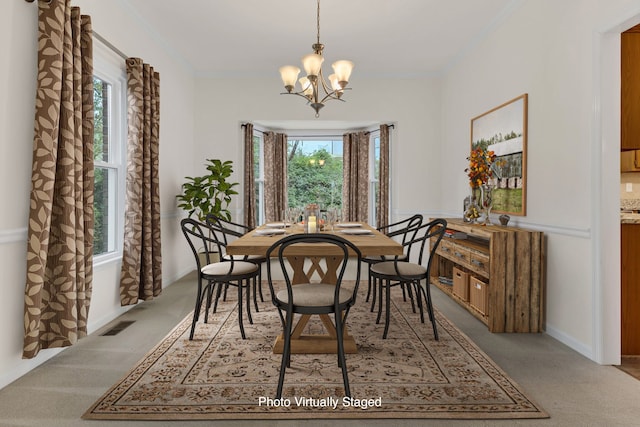 dining area with carpet, a notable chandelier, a healthy amount of sunlight, and ornamental molding