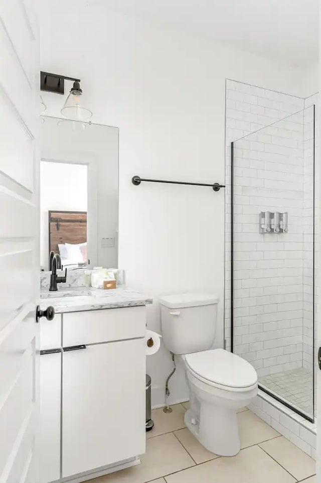 bathroom with vanity, walk in shower, tile patterned flooring, and toilet