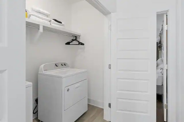 laundry area with light hardwood / wood-style flooring and washer and clothes dryer