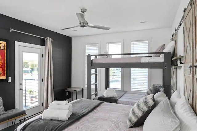 bedroom with a barn door, ceiling fan, and multiple windows