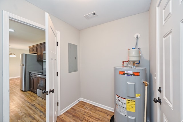 utility room featuring electric panel and electric water heater