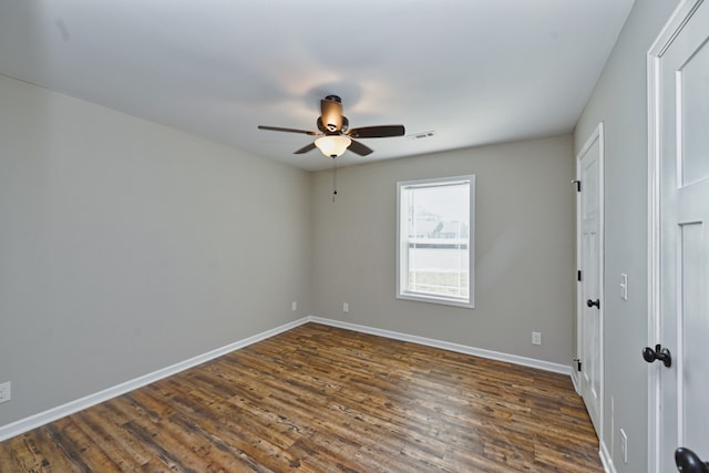 spare room featuring dark wood-type flooring and ceiling fan