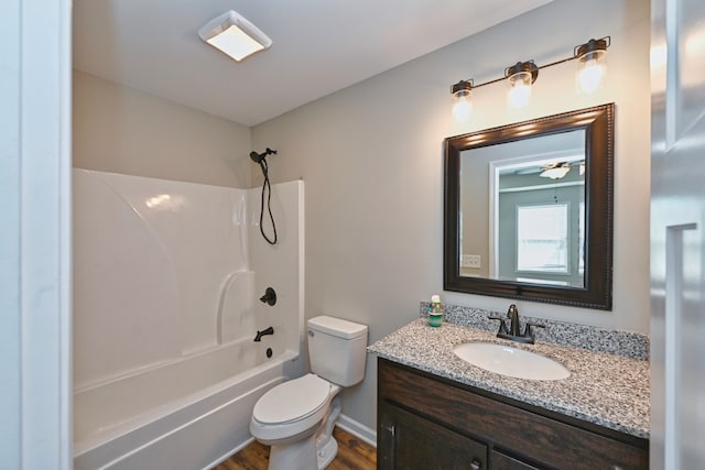 full bathroom featuring ceiling fan, hardwood / wood-style floors, vanity, bathtub / shower combination, and toilet