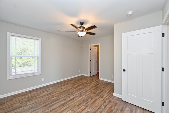 unfurnished bedroom featuring ceiling fan and dark hardwood / wood-style floors