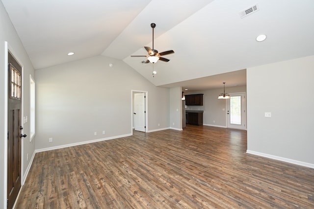 unfurnished living room featuring ceiling fan with notable chandelier, dark hardwood / wood-style flooring, and vaulted ceiling