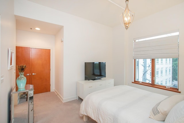 carpeted bedroom featuring an inviting chandelier and a closet