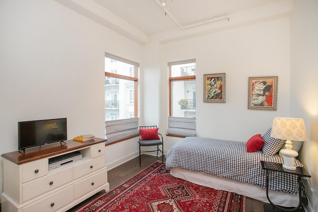 bedroom featuring dark wood-type flooring and track lighting