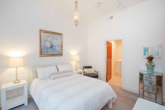 carpeted bedroom with a high ceiling and connected bathroom