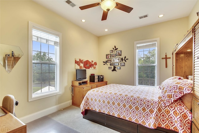 carpeted bedroom with multiple windows and ceiling fan