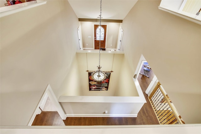 staircase featuring a high ceiling and wood-type flooring