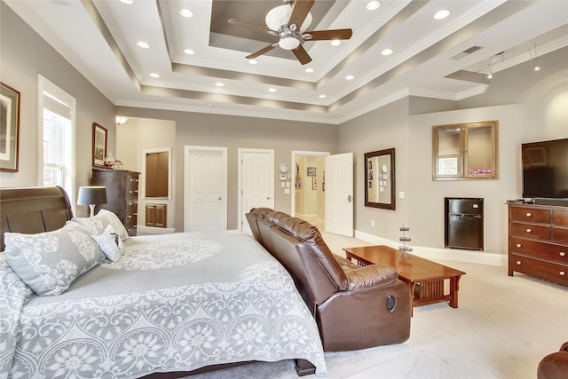 carpeted bedroom with ceiling fan, crown molding, and a tray ceiling