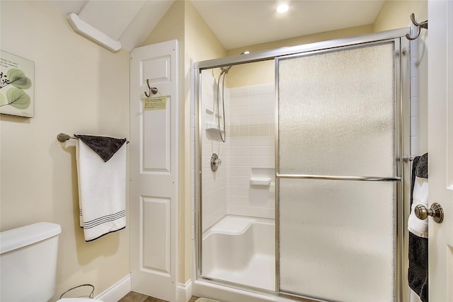 bathroom with a shower with door and toilet