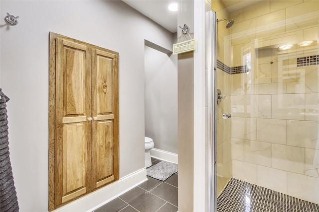 bathroom featuring walk in shower, toilet, and tile patterned flooring