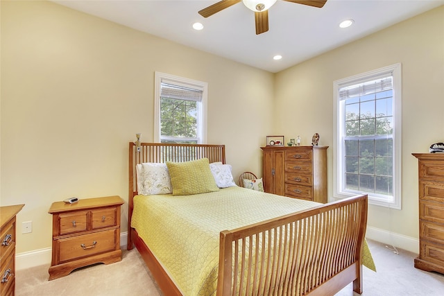 carpeted bedroom featuring multiple windows and ceiling fan