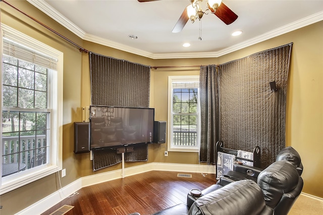 living area featuring ceiling fan, a healthy amount of sunlight, crown molding, and wood-type flooring