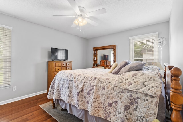 bedroom featuring ceiling fan, a textured ceiling, and dark hardwood / wood-style flooring