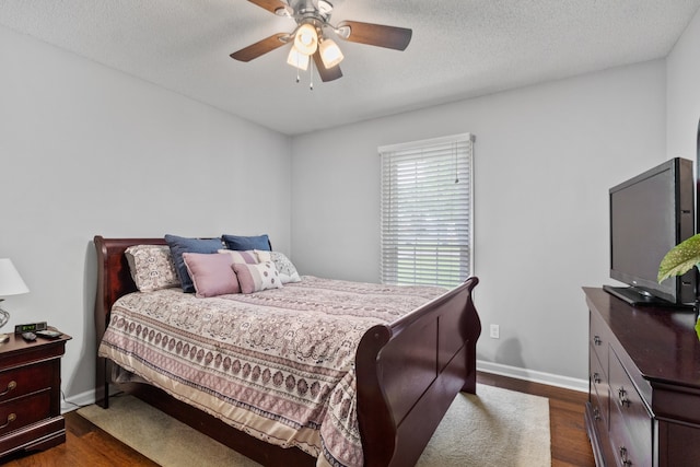 bedroom featuring ceiling fan, dark hardwood / wood-style floors, and a textured ceiling