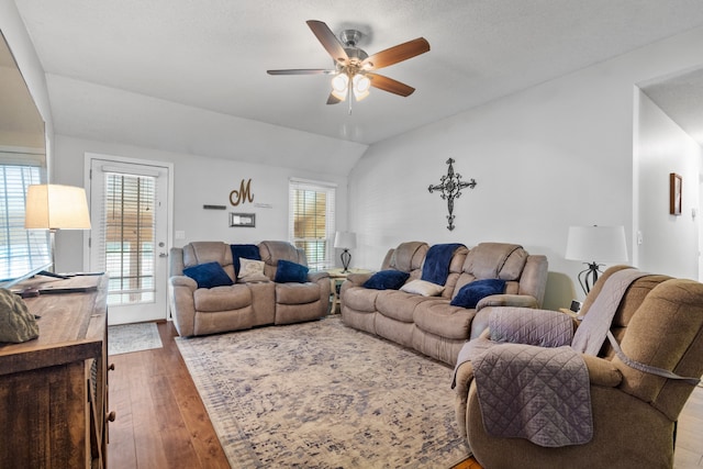 living room featuring a textured ceiling, hardwood / wood-style floors, lofted ceiling, and ceiling fan