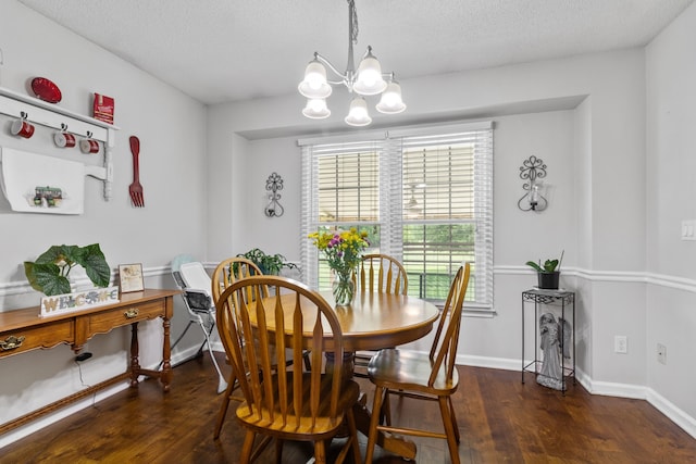 dining area featuring dark hardwood / wood-style floors, a textured ceiling, and a chandelier