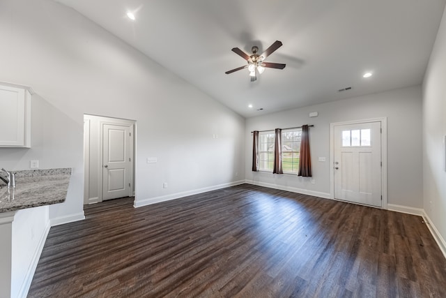 unfurnished living room featuring dark hardwood / wood-style flooring, lofted ceiling, and ceiling fan