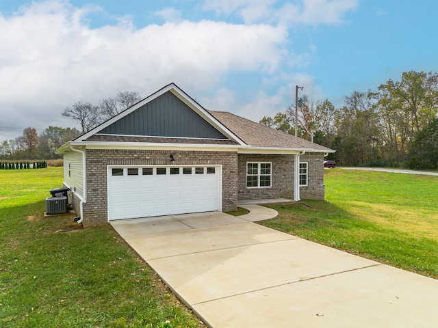 view of front of property featuring a garage, central AC unit, and a front lawn