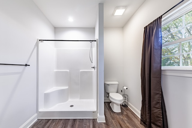 bathroom with toilet, a shower with shower curtain, and hardwood / wood-style flooring