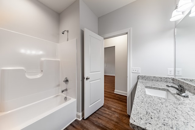 bathroom with wood-type flooring, vanity, and bathtub / shower combination