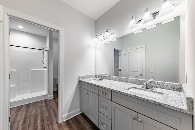 bathroom featuring hardwood / wood-style flooring, vanity, toilet, and walk in shower